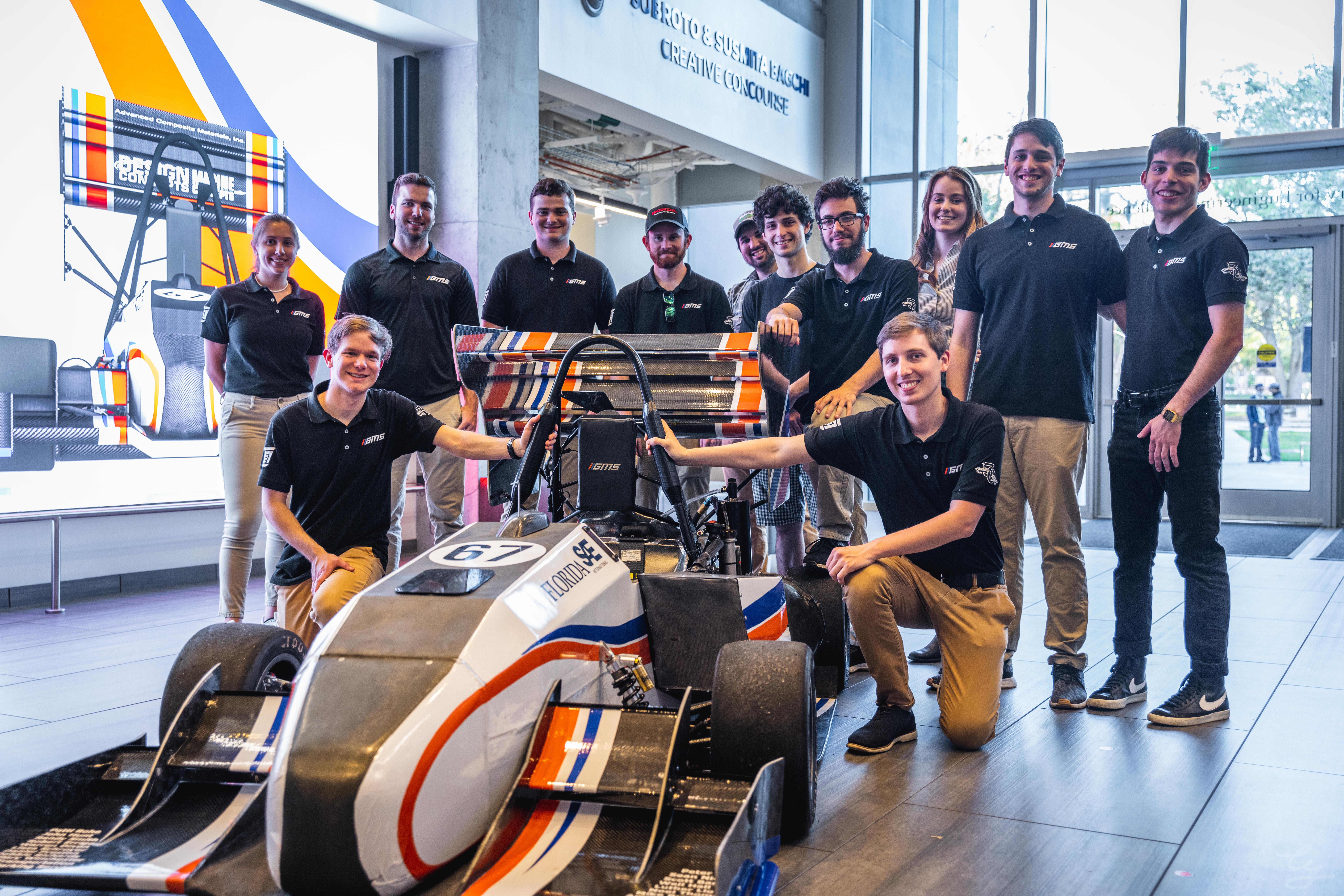 image of our F23 racecar, with the F23 engineering team, located inside the Herbert Wertheim Laboratory for Engineering Excellence